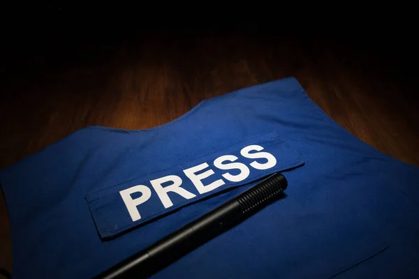 Media Journalism Global Daily News Content Concept. Blue journalist (press) vest in dark with backlight and fog. Media microphone on journalist vest. Selective focus