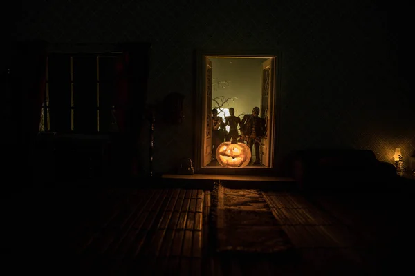 万圣节恐怖的概念与发光的南瓜 一个现实的玩具店客厅 晚上有家具 门和窗户 可怕的僵尸在外面 有选择的重点 — 图库照片