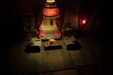Şükran Günü yaratıcı konsepti. Geceleri mobilyası ve penceresi olan gerçekçi bir bebek evi oturma odası. Şükran Günü hindisi maketi. Seçici odak