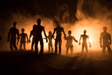 Bulutlu gökyüzü ve sis ile mezarlıktaki zombilerin korkunç görüntüsü, Korku Cadılar Bayramı konsepti. Seçici odak