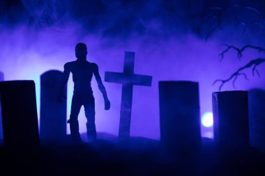 Zombilerin mezarlıktaki ölü ağaç, ay, kilise ve sisli ürkütücü bulutlu gökyüzü, Korku Cadılar Bayramı konsepti. Seçici odak