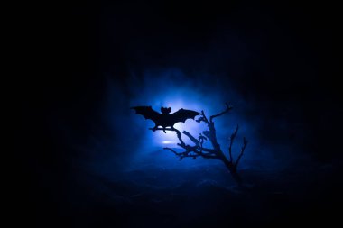 Zombilerin mezarlıktaki ölü ağaç, yarasa ve sisli ürkütücü bulutlu gökyüzü, Korku Cadılar Bayramı konsepti. Seçici odak