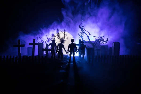 Scary view of zombies at cemetery dead tree, moon, church and spooky cloudy sky with fog, Horror Halloween concept. Selective focus