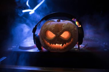 Cadılar Bayramı balkabağı DJ masasında, kulaklıklar koyu arkaplanda ve fotokopi alanı var. Mutlu Cadılar Bayramı Festivali dekorasyonları ve müzik konsepti