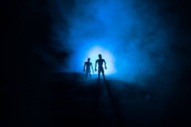 Bulutlu gökyüzü ve sis ile mezarlıktaki zombilerin korkunç görüntüsü, Korku Cadılar Bayramı konsepti. Seçici odak