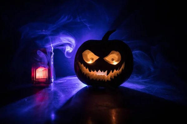 Halloween pumpkin smile and scary eyes for party night. Close up view of scary Halloween pumpkin with eyes glowing inside at black background. Selective focus