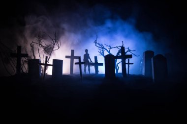 Zombilerin mezarlıktaki ölü ağaç, ay, kilise ve sisli ürkütücü bulutlu gökyüzü, Korku Cadılar Bayramı konsepti. Seçici odak