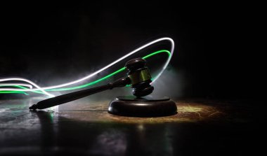 Hukuk, adalet kavramı. Yaratıcı çizim masası süslemesi hakimin tokmağı ile sisli arka planda renkli ışık ile. Seçici odak