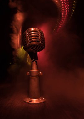 Arka planda arka ışıklandırmalı Retro tarzı mikrofon. Ses, müzik ve karaoke için klasik gümüş mikrofon. Konuşma yayın ekipmanı. Canlı pop, rock müzik performansı. Seçici odak