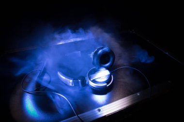 DJ müzik kulübü konsepti. Kulaklıkları koyu arkaplanda renkli ışıkla kapat. Seçici odak