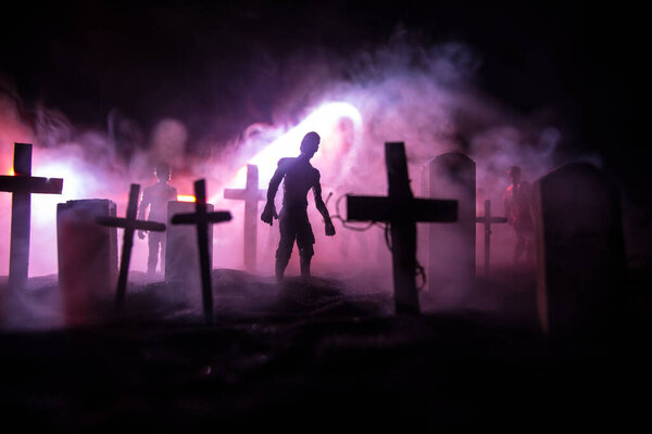 Scary view of zombies at cemetery dead tree, moon, church and spooky cloudy sky with fog, Horror Halloween concept. Selective focus