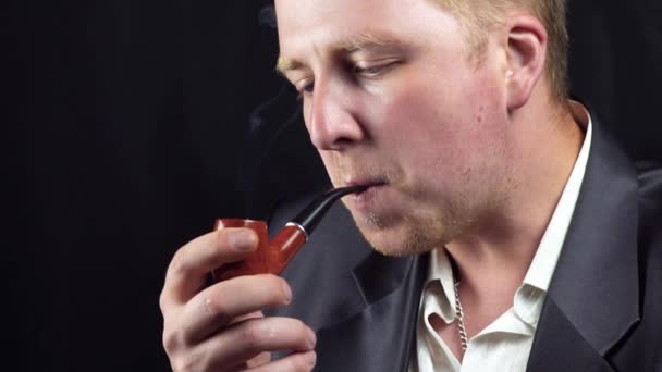 Um homem fuma um cachimbo — Vídeo de Stock