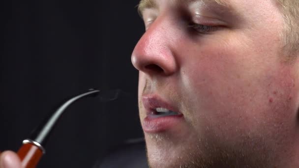 Un hombre fuma una pipa — Vídeo de stock