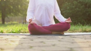 Dışarıda yoga yapan bir kadın.