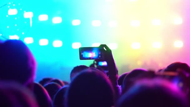 Мужчина стреляет на концерте по телефону — стоковое видео