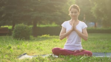 Dışarıda yoga yapan bir kadın.