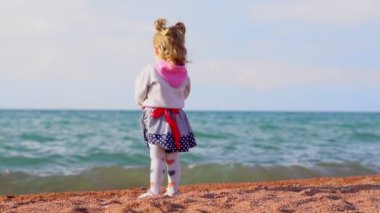 Çocuk deniz kenarında duruyor