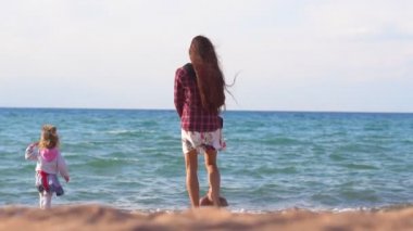 Anne ve kızı deniz kenarında.