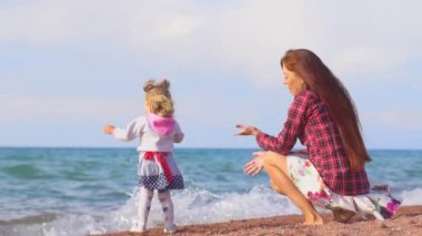 Anne ve kızı deniz kenarında.