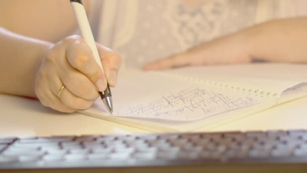 Uma mulher idosa escreve com uma caneta — Vídeo de Stock