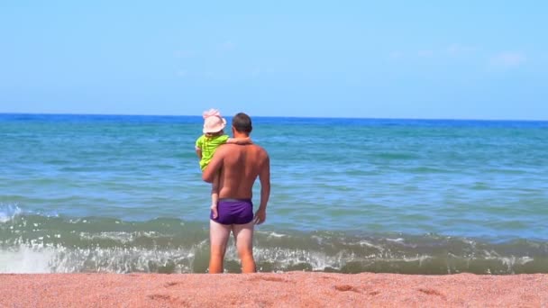 Батько стоїть біля моря як дитина — стокове відео