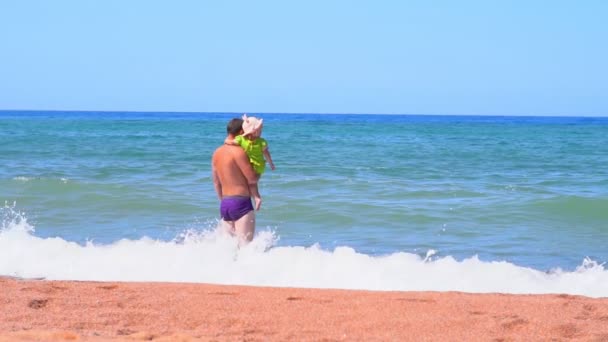 Отец стоит у моря, когда был ребенком — стоковое видео