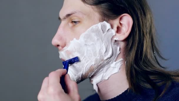En man rakar med en rakhyvel — Stockvideo