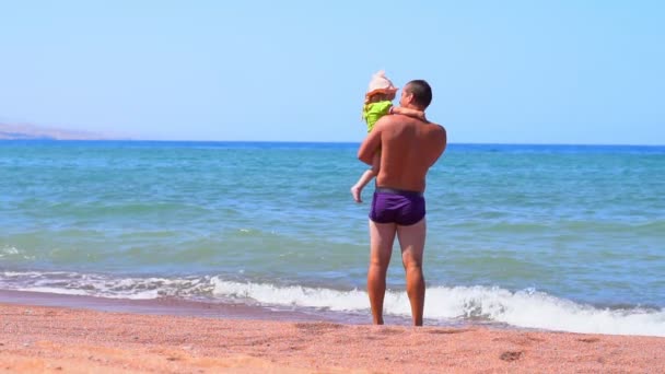 Father stands by the sea as a child — Stock Video