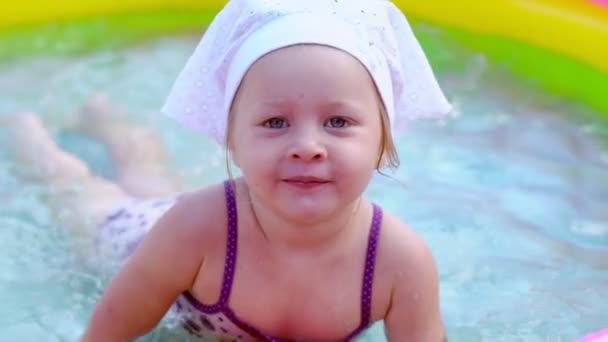 Un niño nada en una piscina inflable — Vídeos de Stock