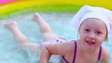 bir çocuk şişme havuzda yüzerler