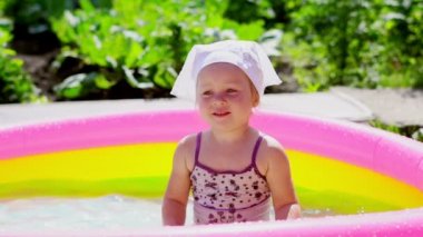 bir çocuk şişme havuzda yüzerler