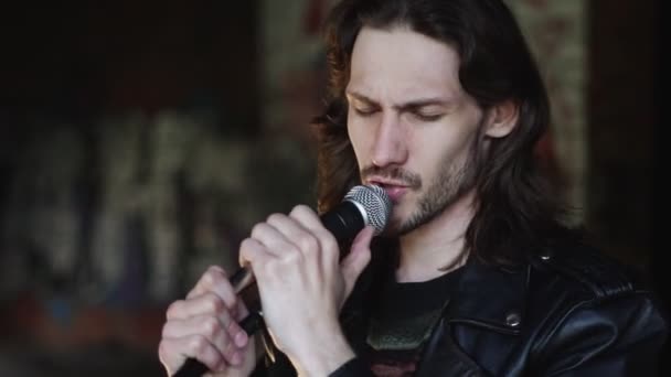 Een zanger zingt in een microfoon in een oud gebouw — Stockvideo