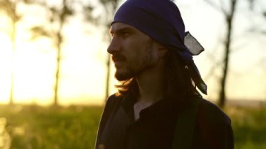 Gün batımında bir adam tarlada yürür.