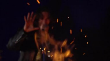 Şarkıcı mikrofonda sokakta şarkı söylüyor.