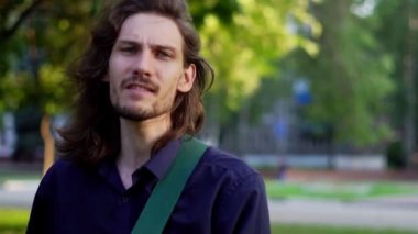 Şarkıcı mikrofonda sokakta şarkı söylüyor.