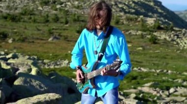Adam sahada gitar çalıyor.
