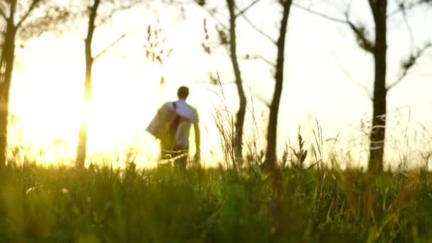 Ένας Άντρας Περπατάει Ένα Χωράφι Ηλιοβασίλεμα — Αρχείο Βίντεο