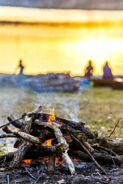 İnsanlar kamp kamp ateşi ve sosis ızgara, göl üzerinde açık piknik