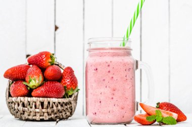 Meyve, çilek milkshake taze çilek veya beyaz arka plan üzerinde kavanoza yoğurt ile sağlıklı güler yüzlü
