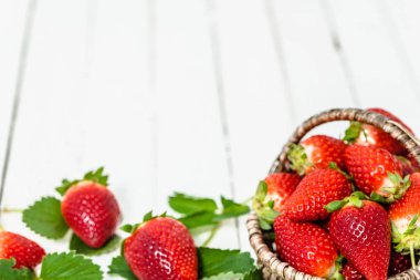 Organik çilek beyaz arka plan üzerinde. Masada sepette taze kırmızı meyveler.