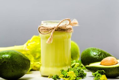 Sebze içkiyle yeşil sebzeler, avokado, sağlıklı kahvaltı ve vejetaryen gıda kavramı ile güler yüzlü kavanoz