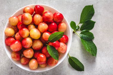Beyaz arka plan, sarı taze kiraz, tatlı meyve, üstten görünüm plaka üzerinde renkli kiraz