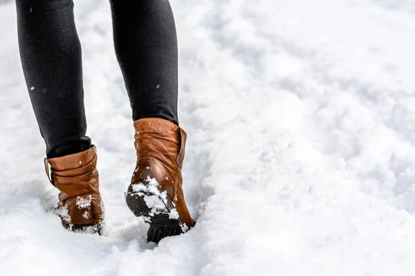 Female feet in boots and leggings, winter walking in snow Stock