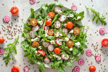Roka, domates, beyaz peynir ile taze sebze salatası. Sağlıklı gıda, vejetaryen yemek plaka üzerinde.