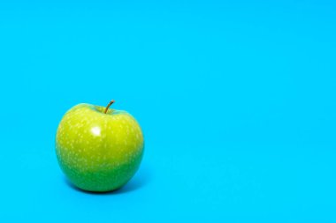 Mavi zemin üzerine Yeşil taze elma