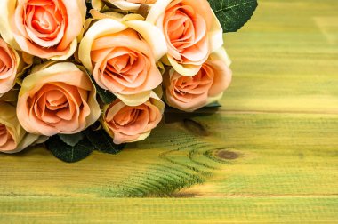 Anneler günü, ahşap masaya çiçek ile arka plan olarak gül buketi