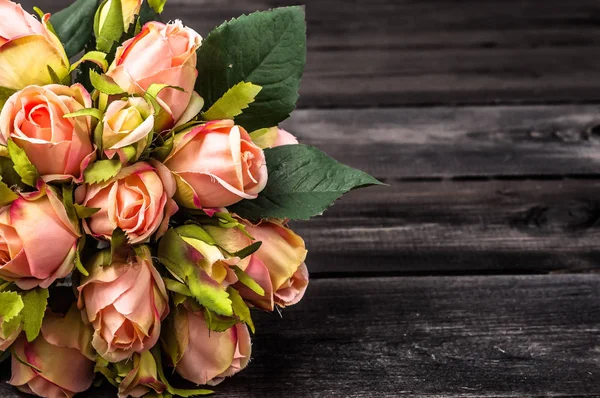 Anneler günü, ahşap masaya çiçek ile arka plan olarak gül buketi