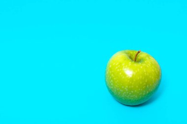 Yeşil elma üzerinde mavi arka plan izole