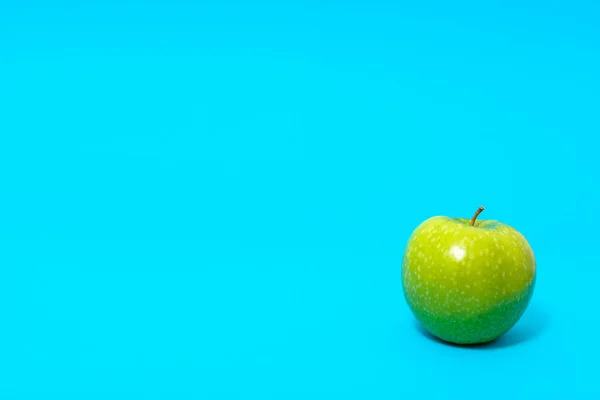 在蓝色背景上的新鲜青苹果 — 图库照片