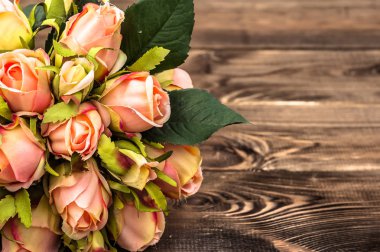 Ahşap masaya çiçek ile anneler günü arka plan olarak gül buketi